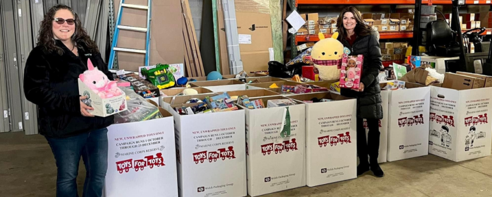 child pulling sock off of baby's foot sitting on hardwood floors