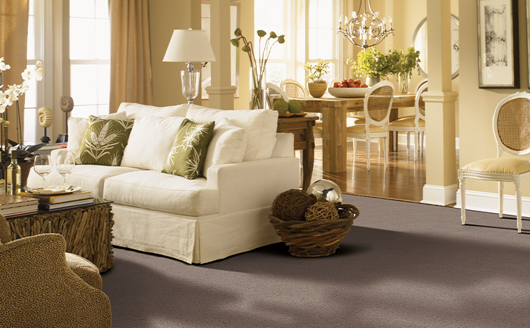 greyish-brown flooring transitioning to wood flooring in living room